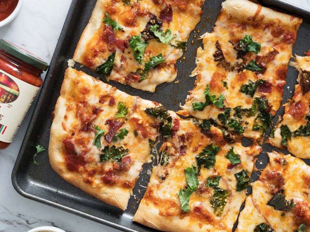 Kale red onion bacon pizza with melted cheese